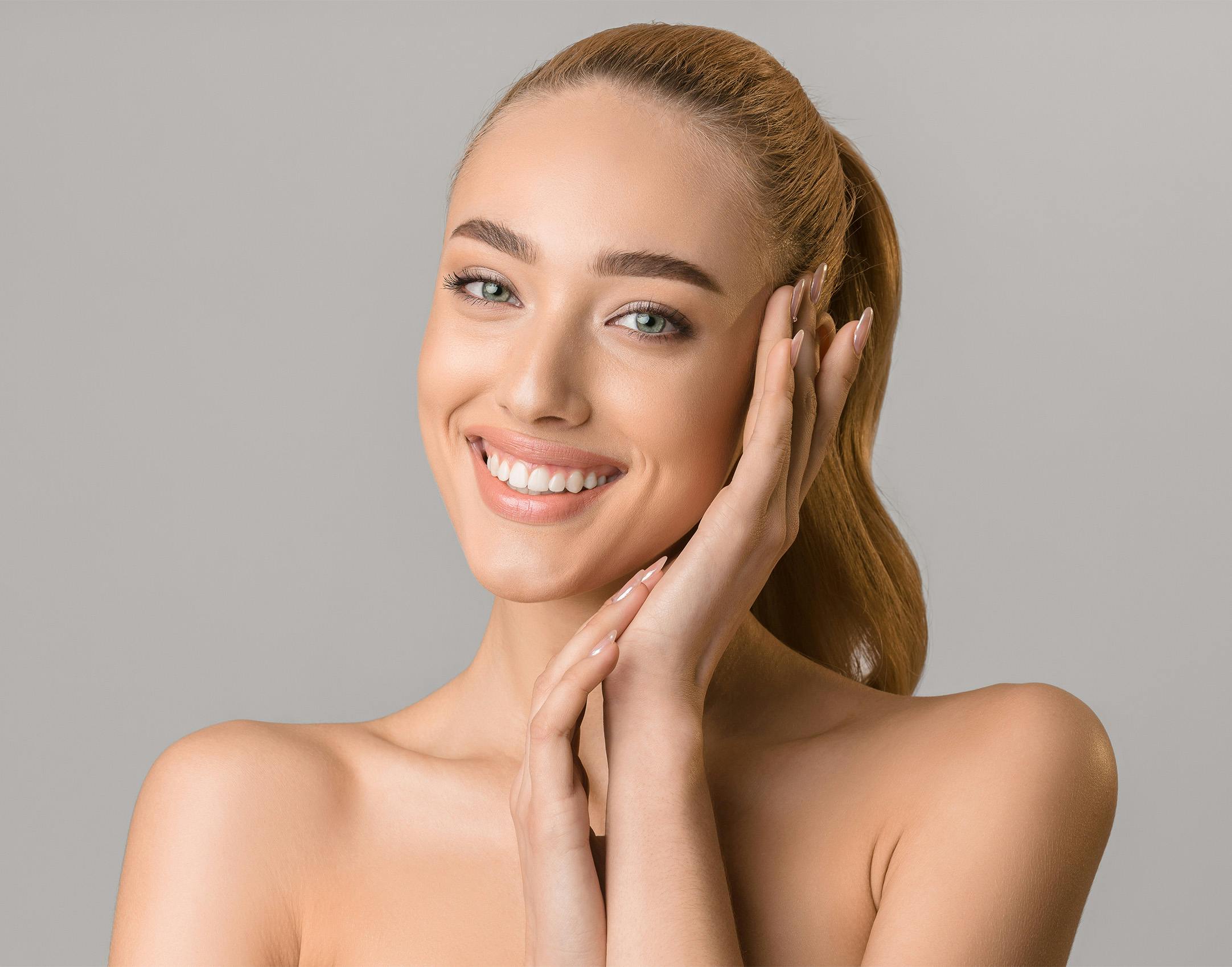 woman smiling and putting her hands near her face
