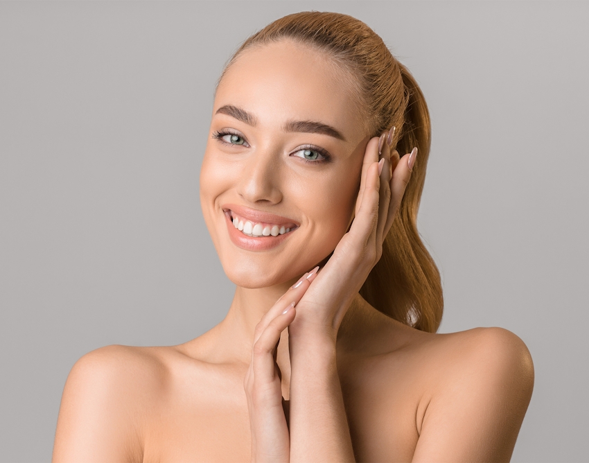 woman smiling and putting her hands near her face