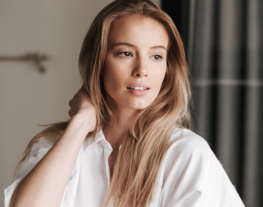 woman with long blonde hair wearing a white shirt