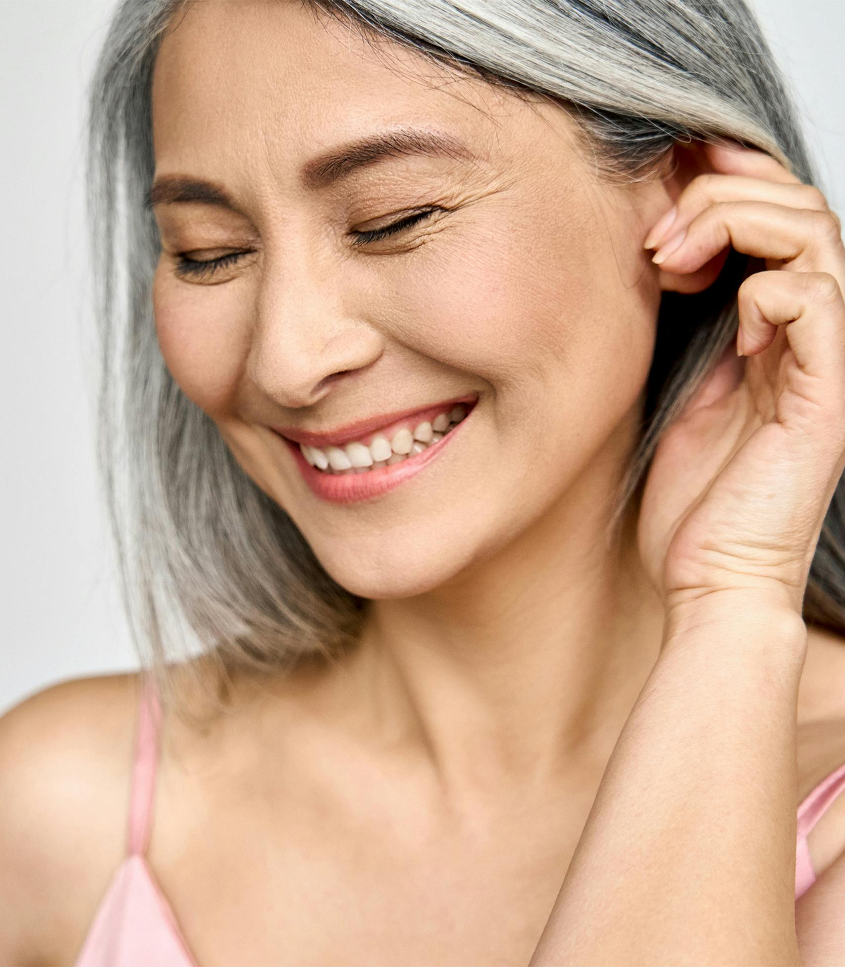 woman smiling and pushing he hair behind her ear