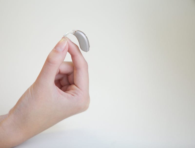 person holding hearing aid