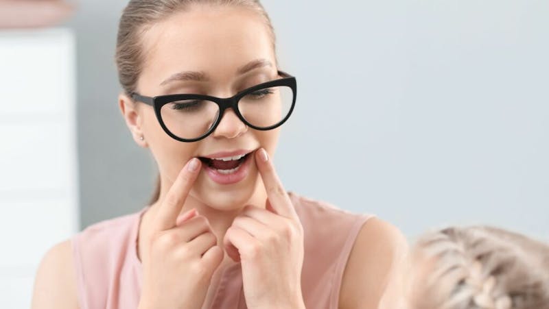 woman holding her mouth