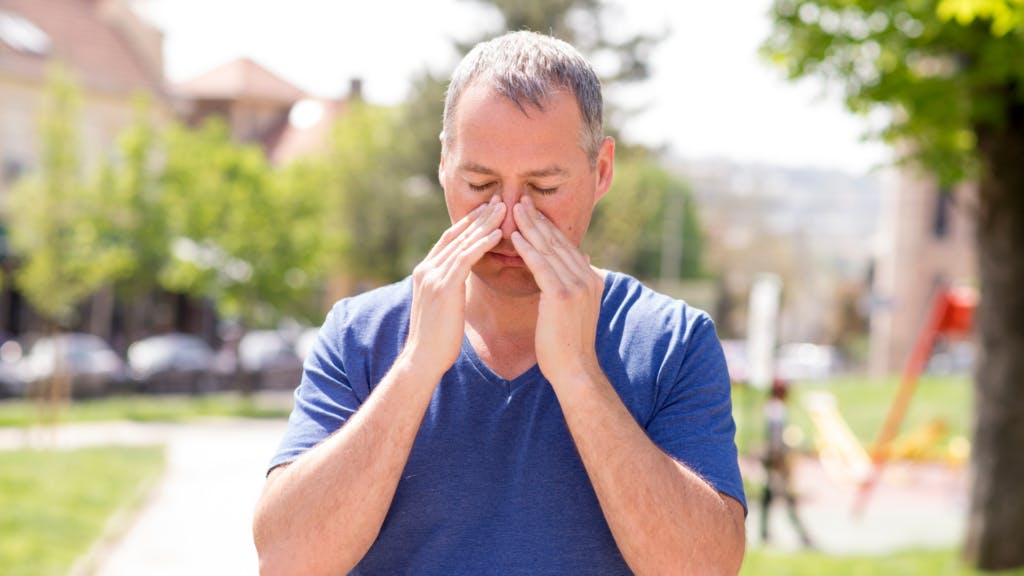 man blowing his nose