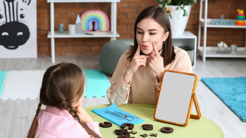 speech pathologist with a young girl