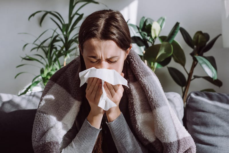 Woman sick and blowing nose
