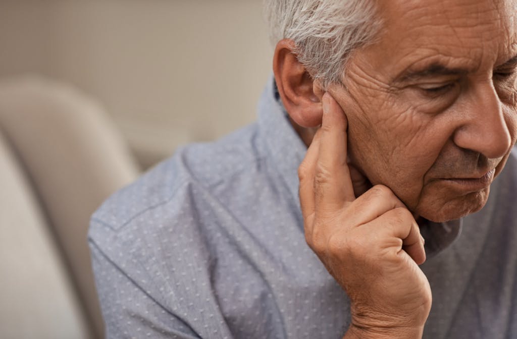 Older man holding hear