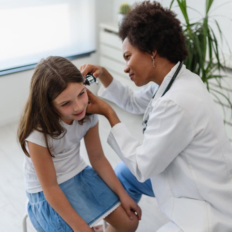 Doctor checking out child's ear