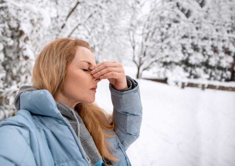 woman holding on to bridge of her nose