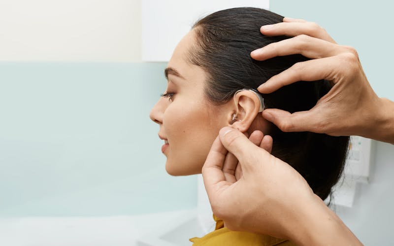 woman being fit for a hearing aid