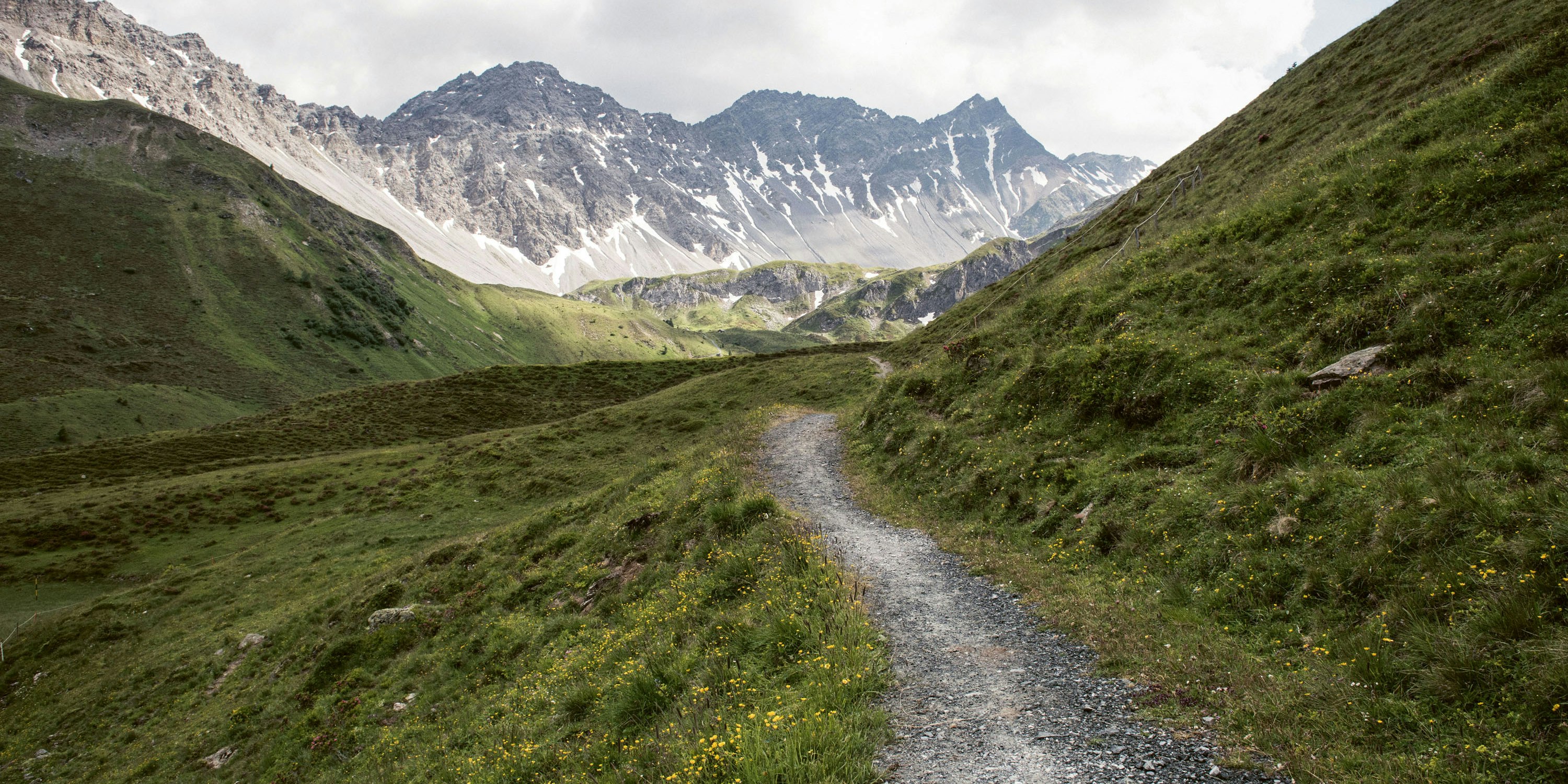 Ein Wanderweg zwischen den Bergen Ein Wanderweg zwischen den Bergen