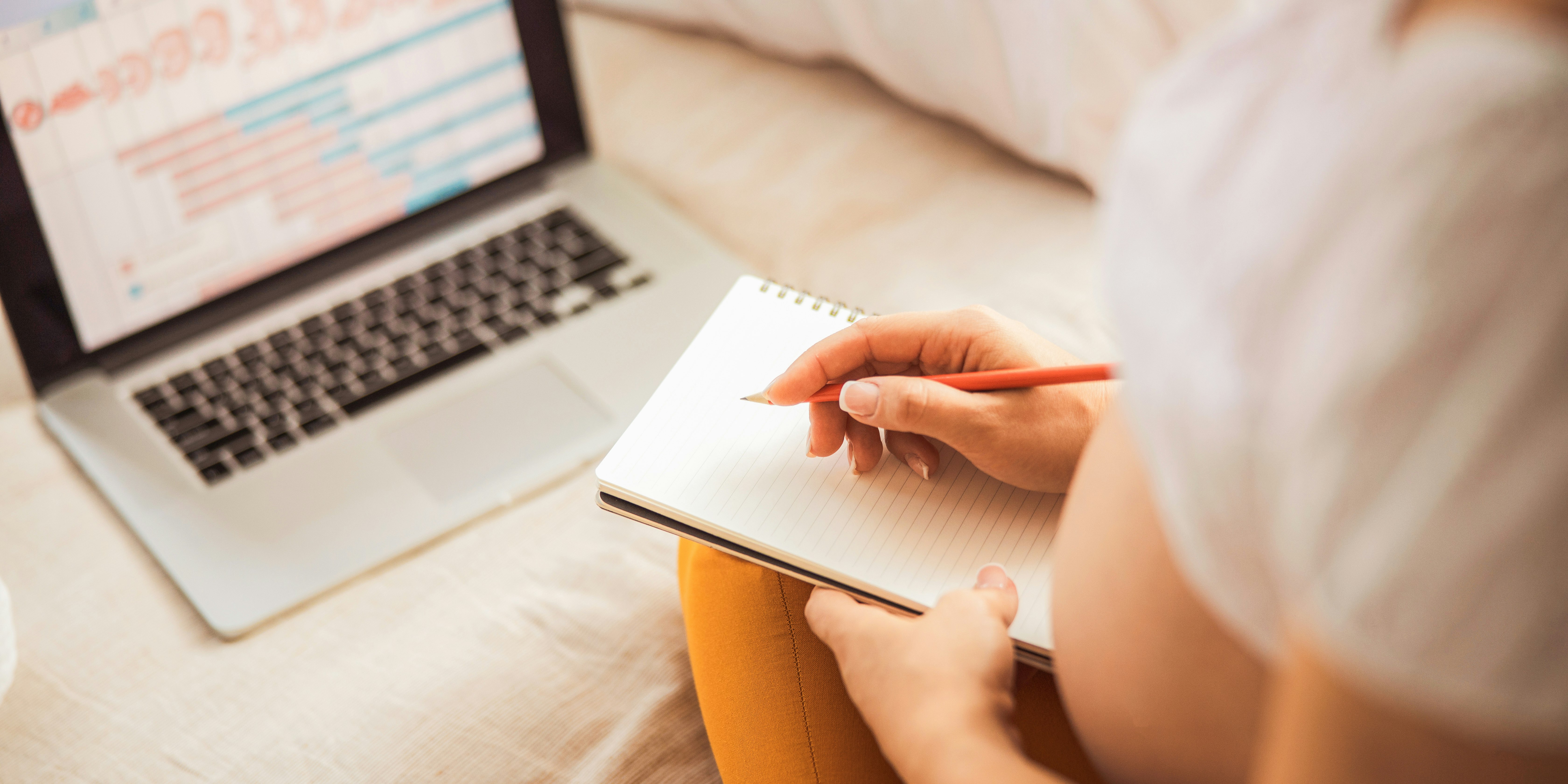 schwangere_frau_vor_dem_laptop_sich_notizen_machend schwangere_frau_vor_dem_laptop_sich_notizen_machend