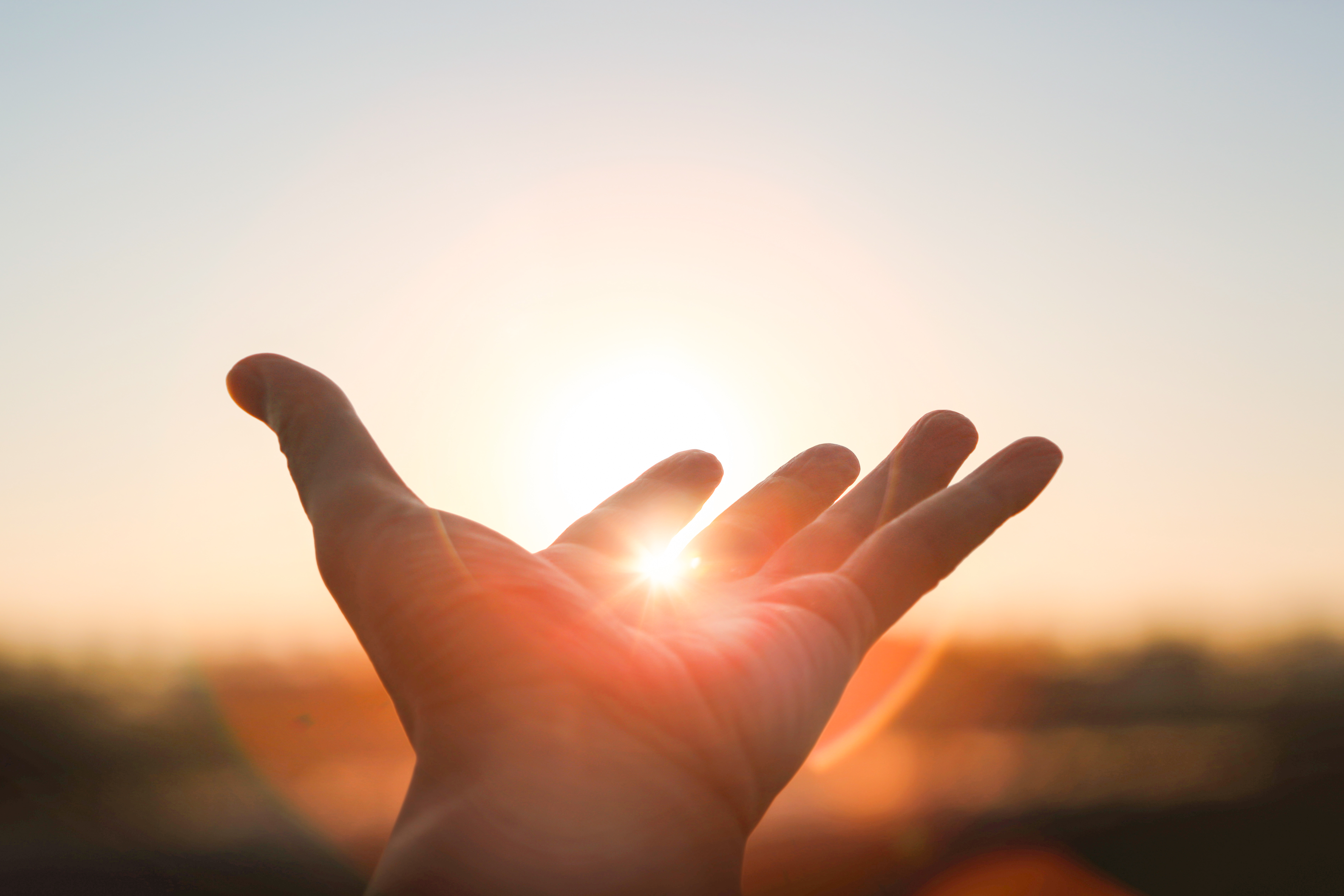 hand_mit_sonnenstrahlen_im_hintergrund