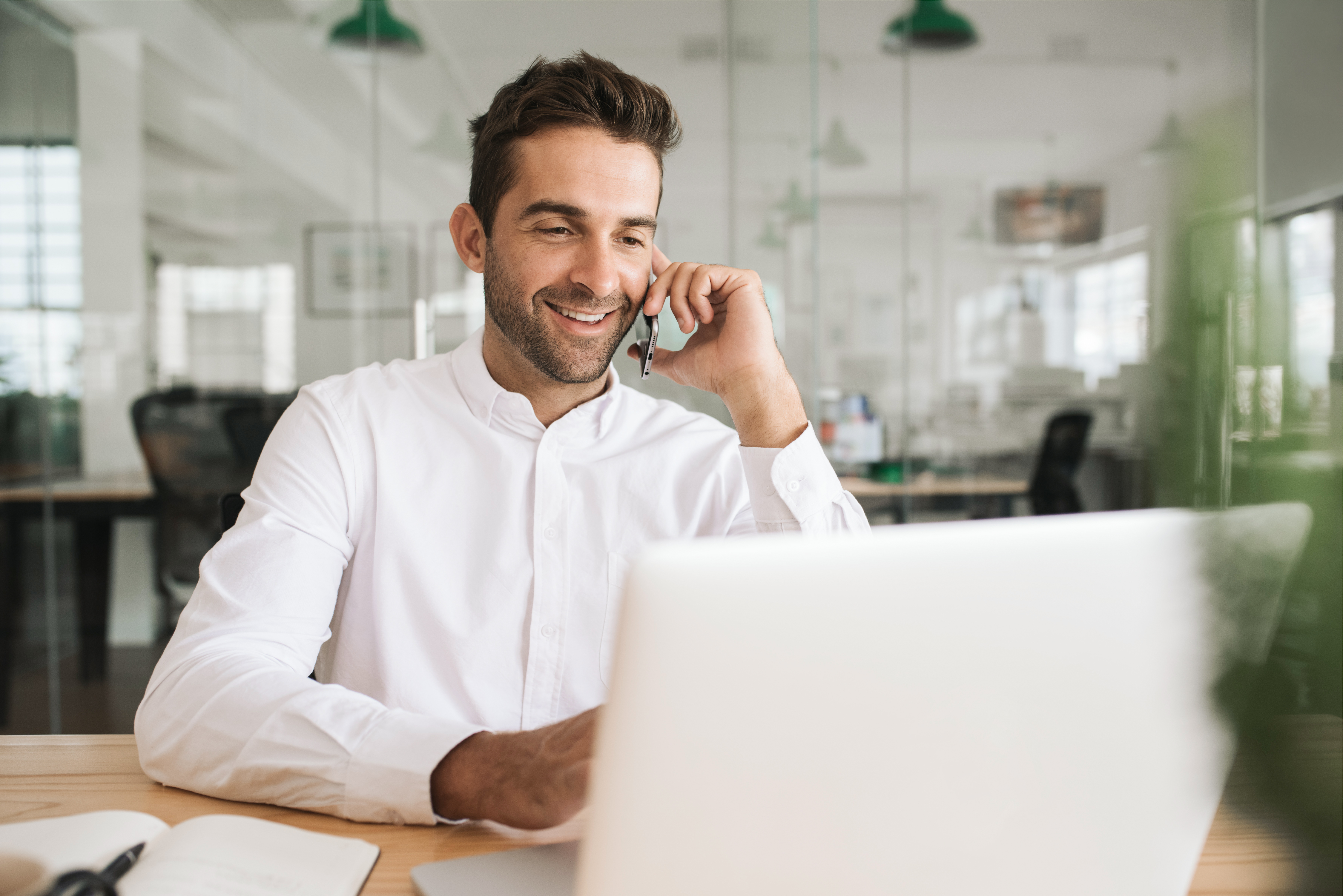 formeller_mann_am_telefon_vor_einem_laptop
