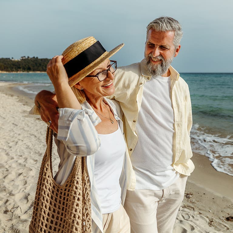 older couple walking on a beach