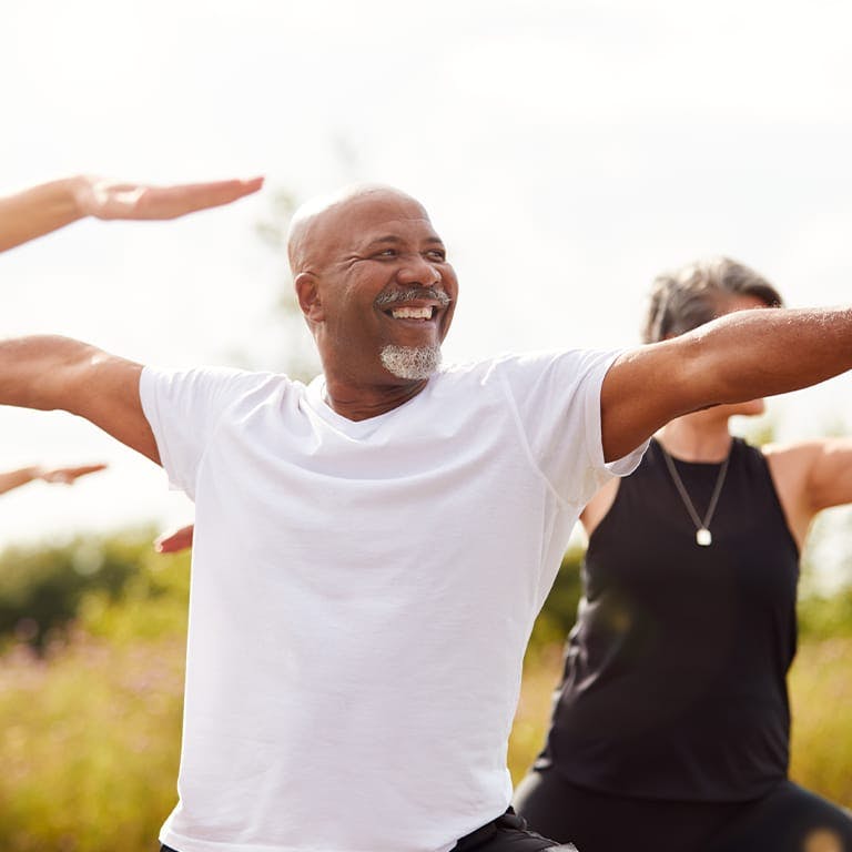 older people doing yoga outside