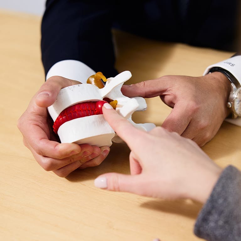 person pointing to a fake spine