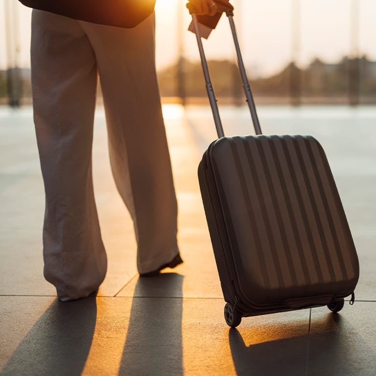 person rolling a suitcase