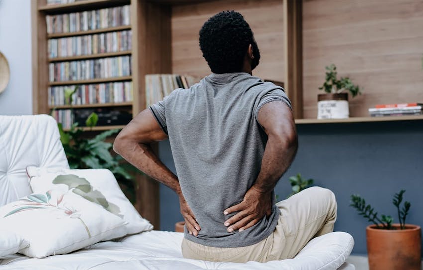 man holding his lower back in pain
