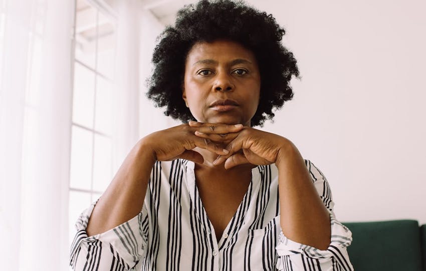 woman holding her hands under her chin