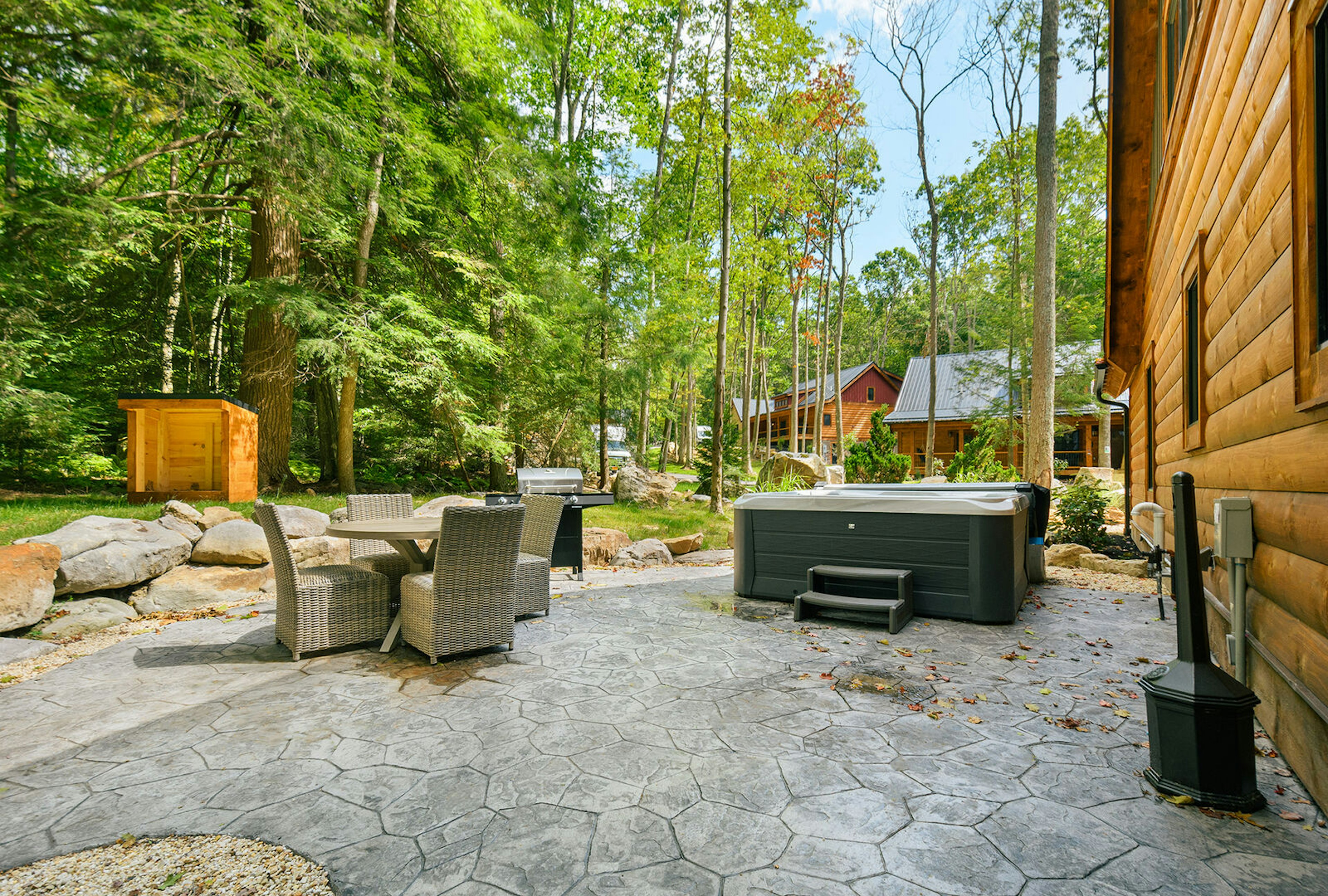 The patio includes outdoor dining and a private hot tub.