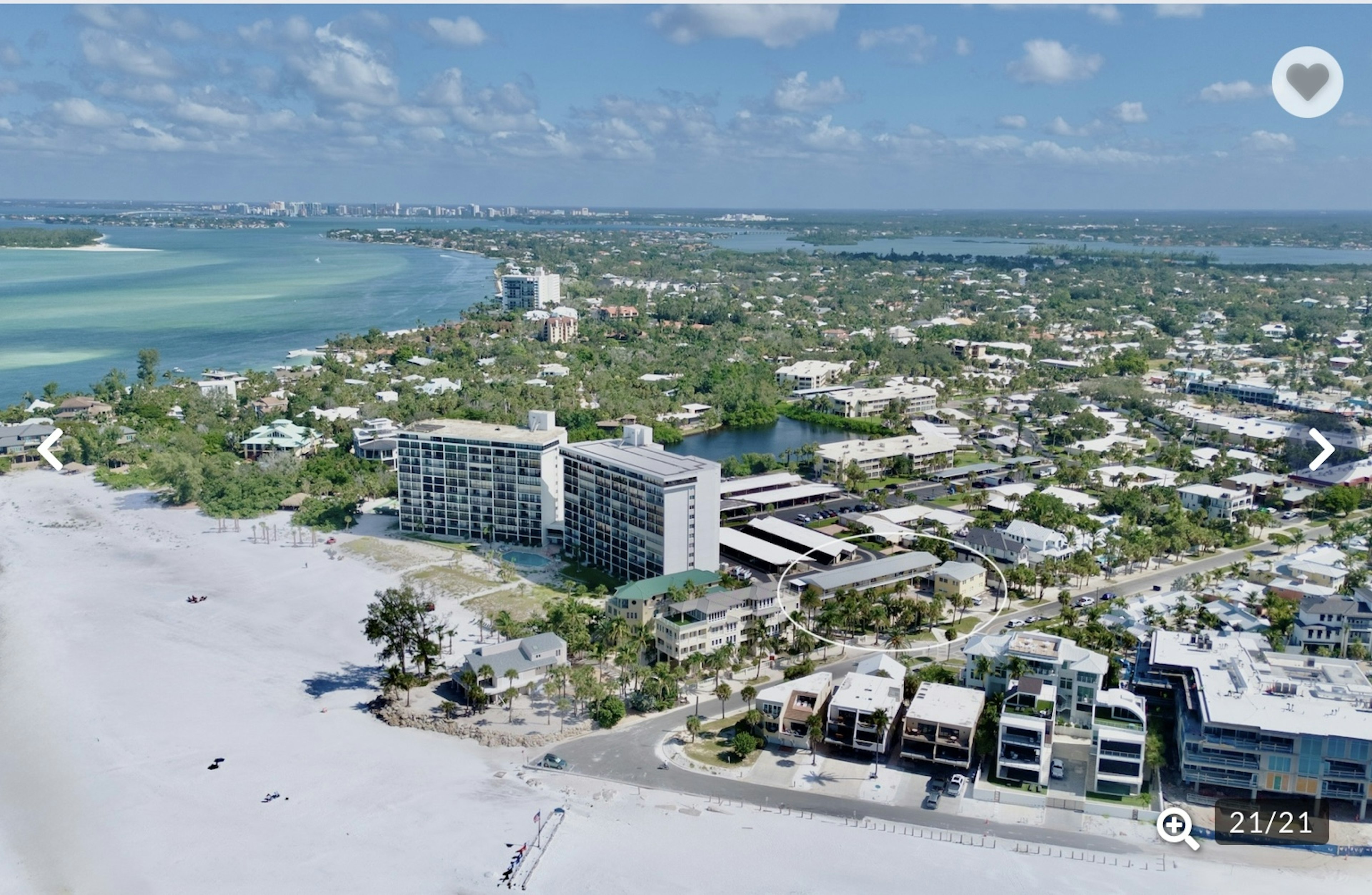 Stunning aerial view of the beachfront property and surrounding coastal community with pristine white sand beaches and turquoise waters.
