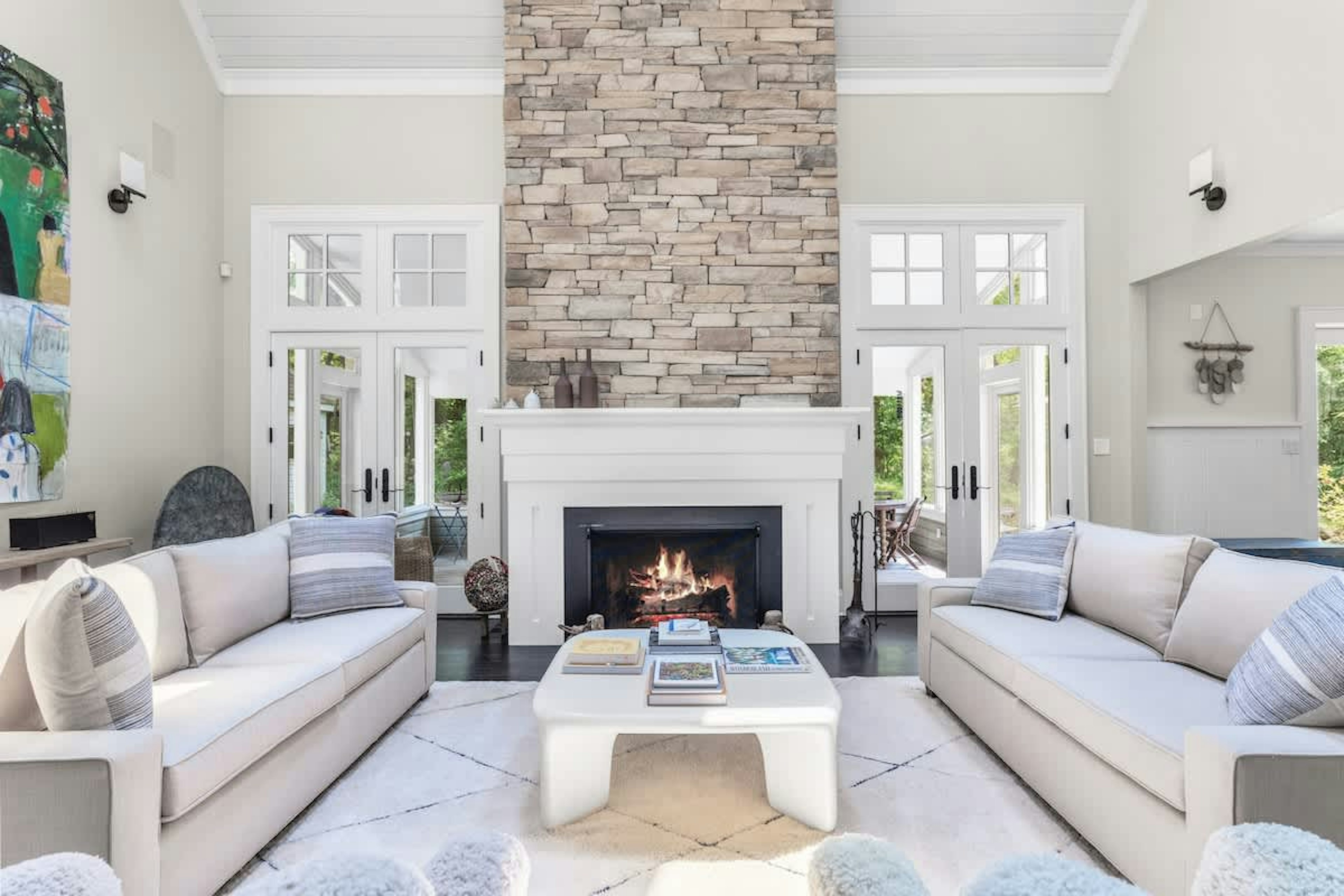 Soaring ceilings, sleek sofas, and a glowing stone fireplace.