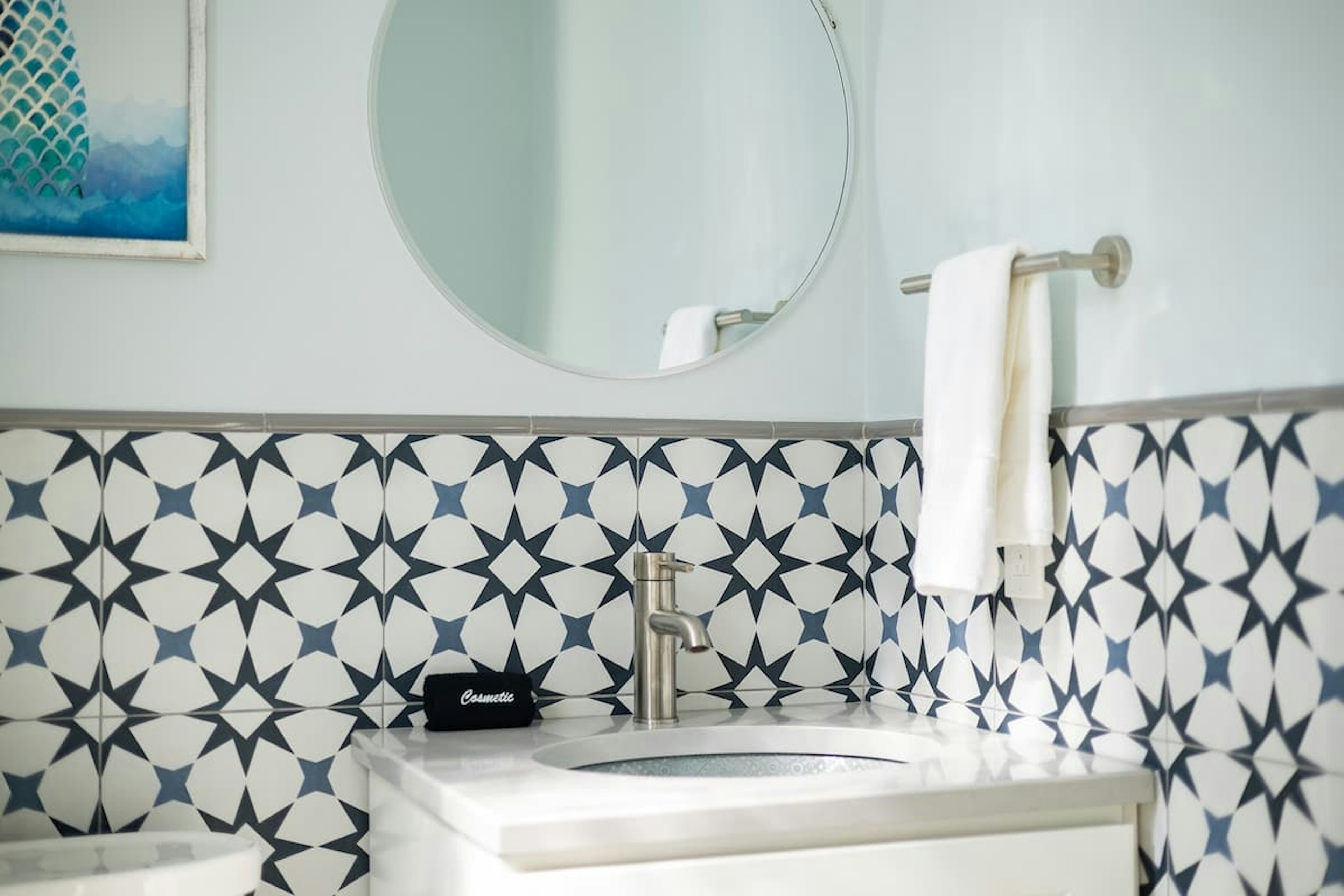 A stylish half bath with geometric tile and modern touches.