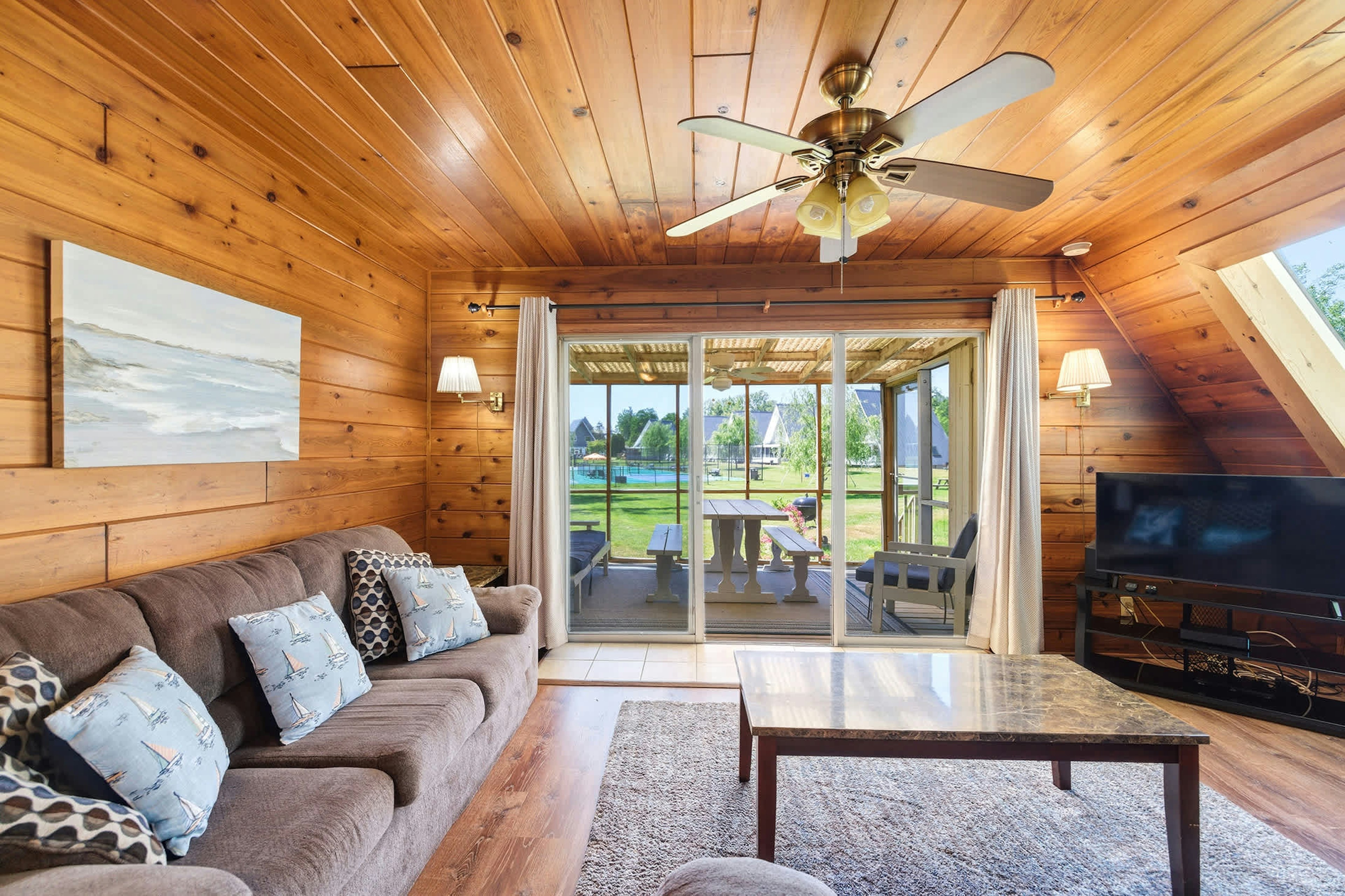 Chalet #71 living room with sliding door access to the screened porch and resort views beyond.
