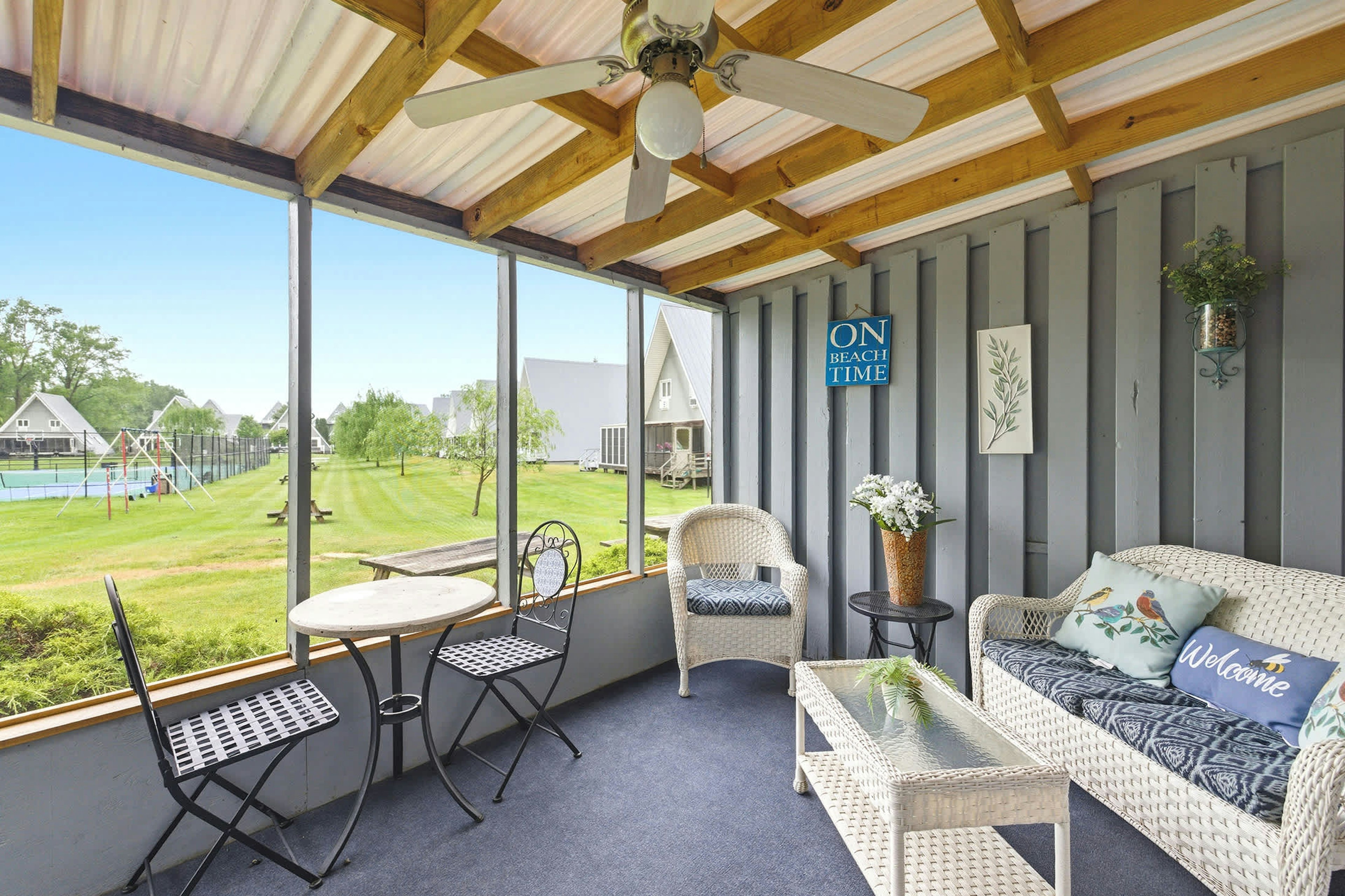 Resort grounds and tennis courts create a scenic porch backdrop.