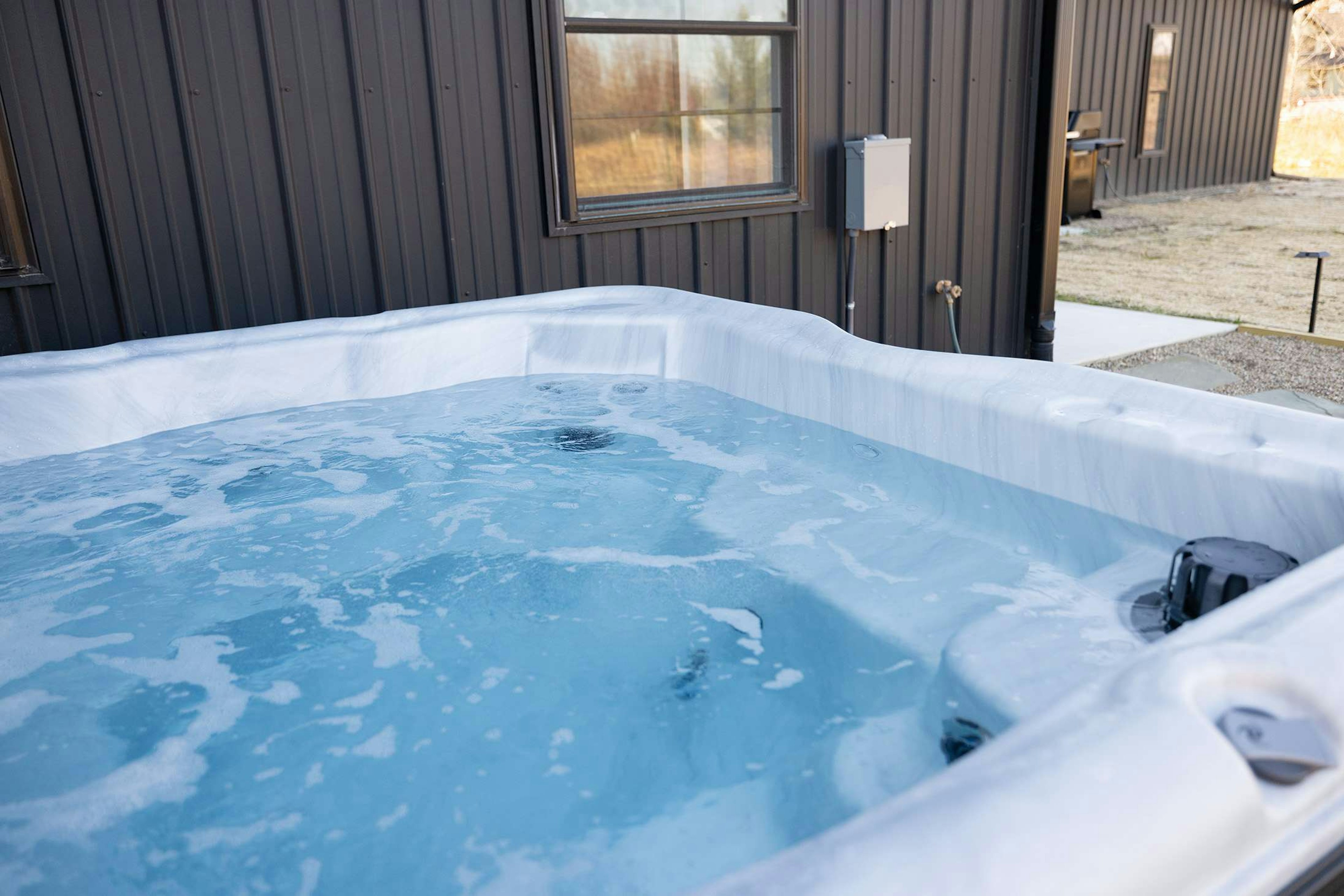 Indulge in a warm soothing soak in your private outdoor hot tub retreat.