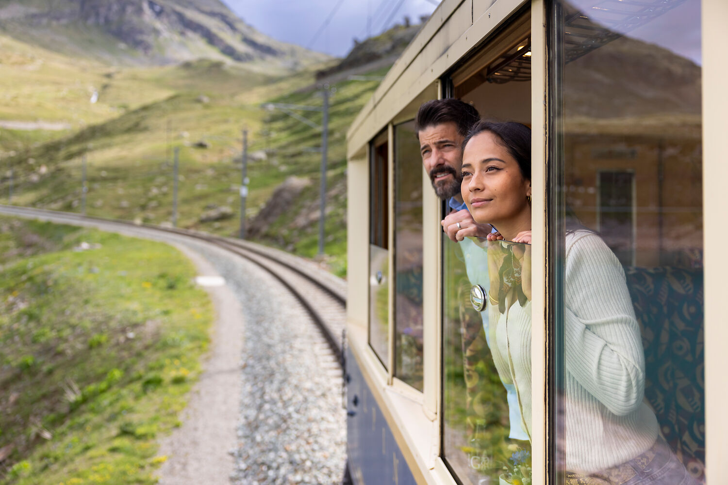 NICOLA PITARO Couple standing at window in Bernina Express Pullman Class looking at landscape