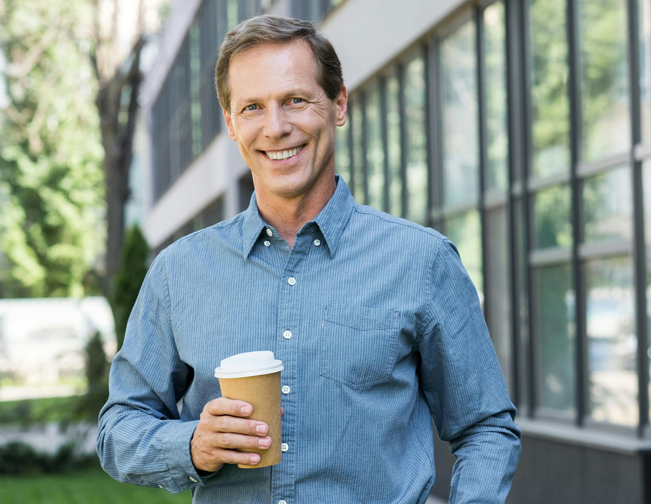 Man holding coffee smiling