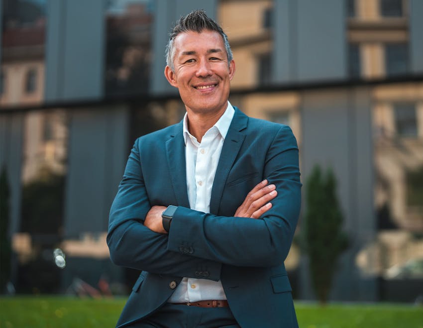 Man standing with arms crossed smiling