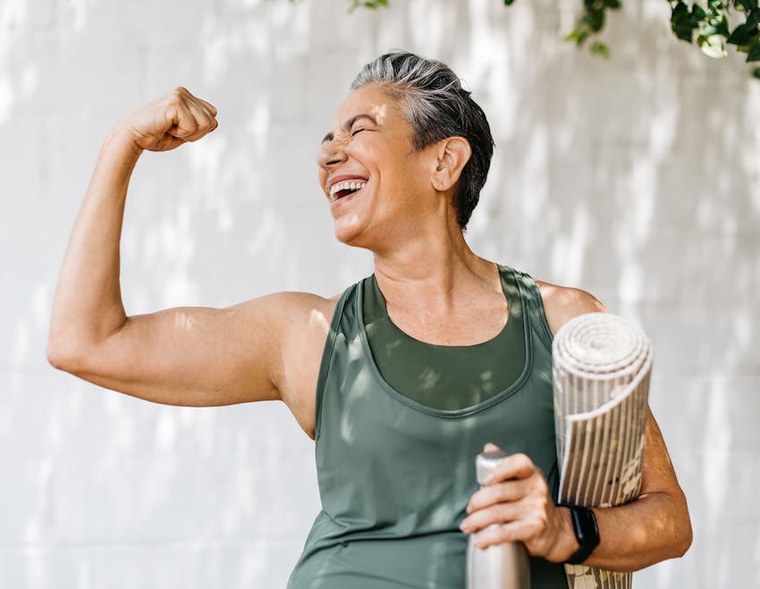 Woman flexing muscle and smiling
