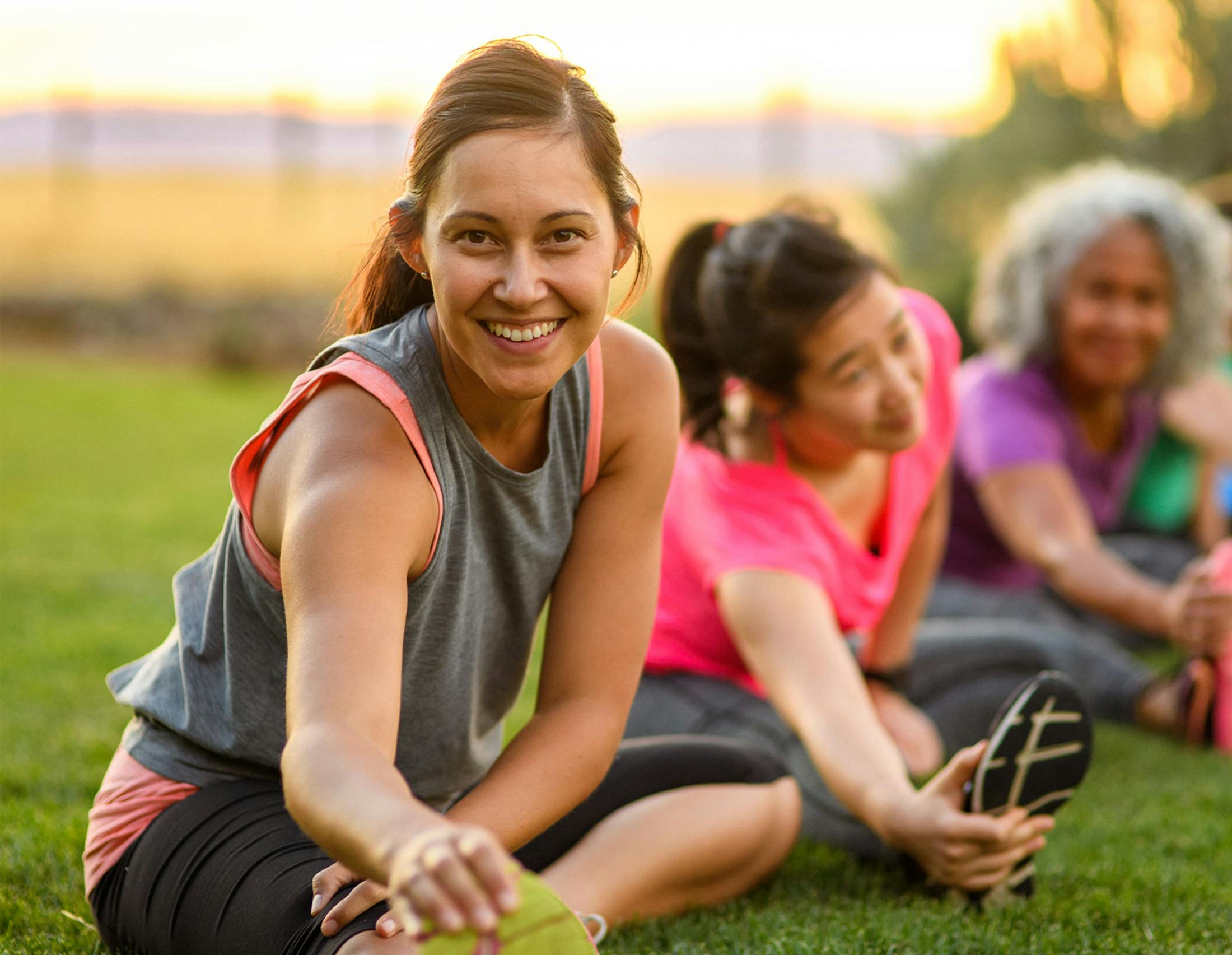 Woman stretching with a group smiling