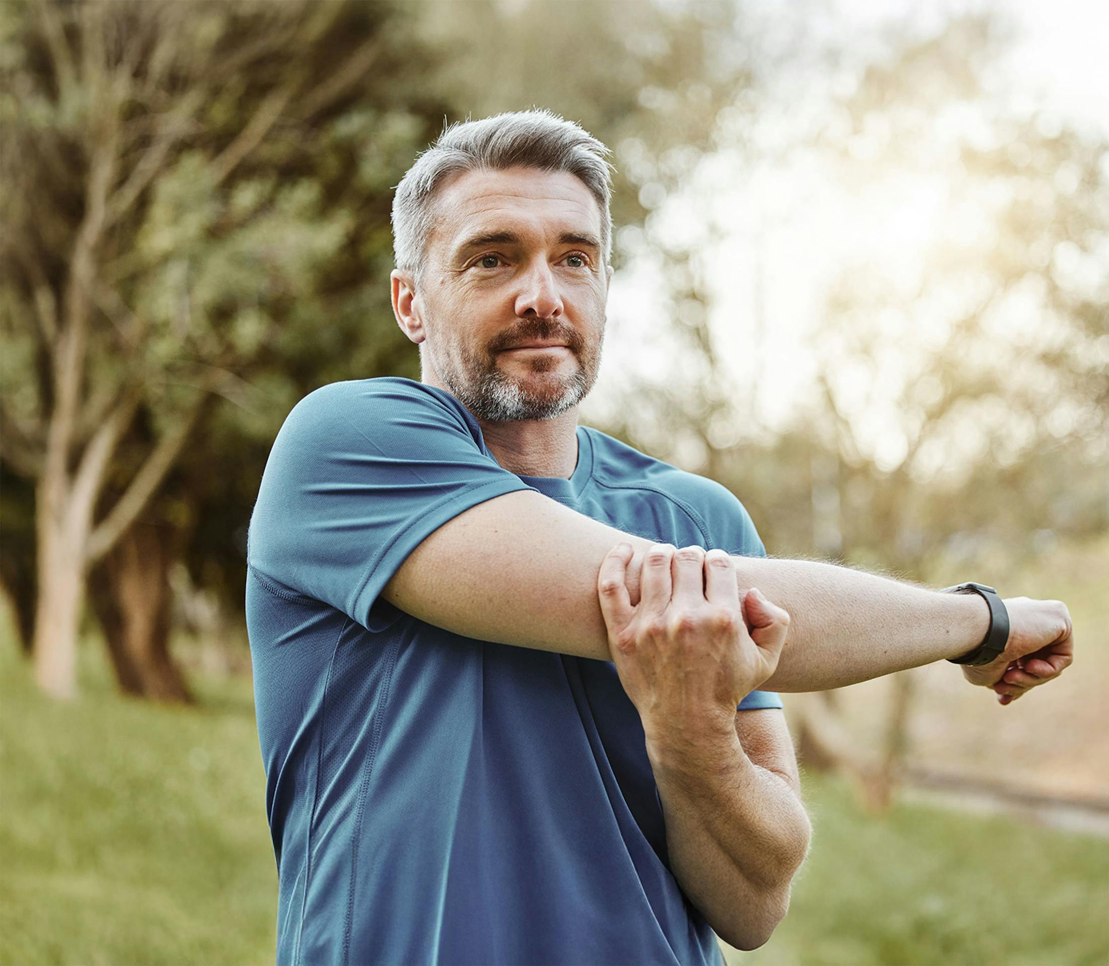 Man stretching his shoulder outside