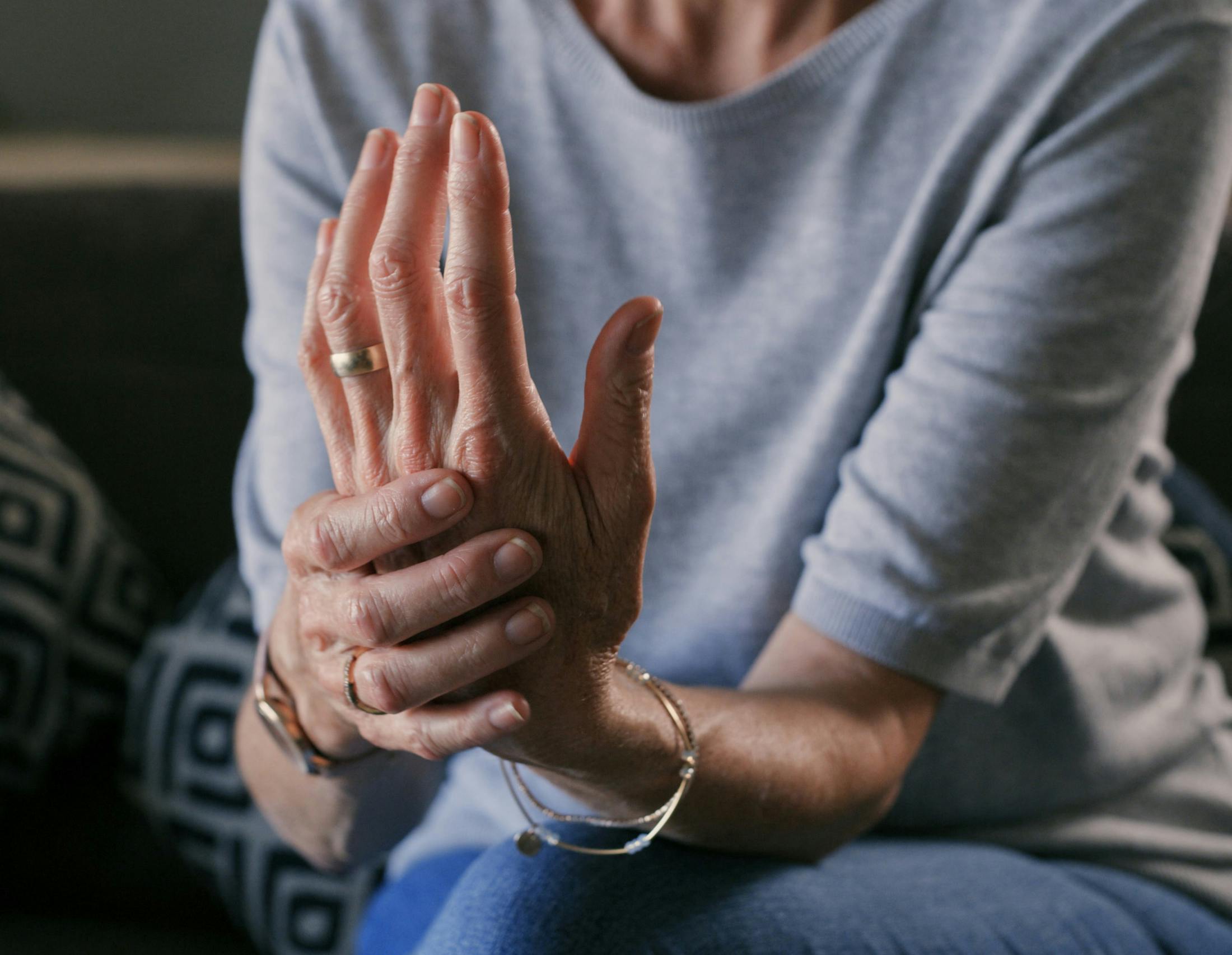woman holding hand in pain