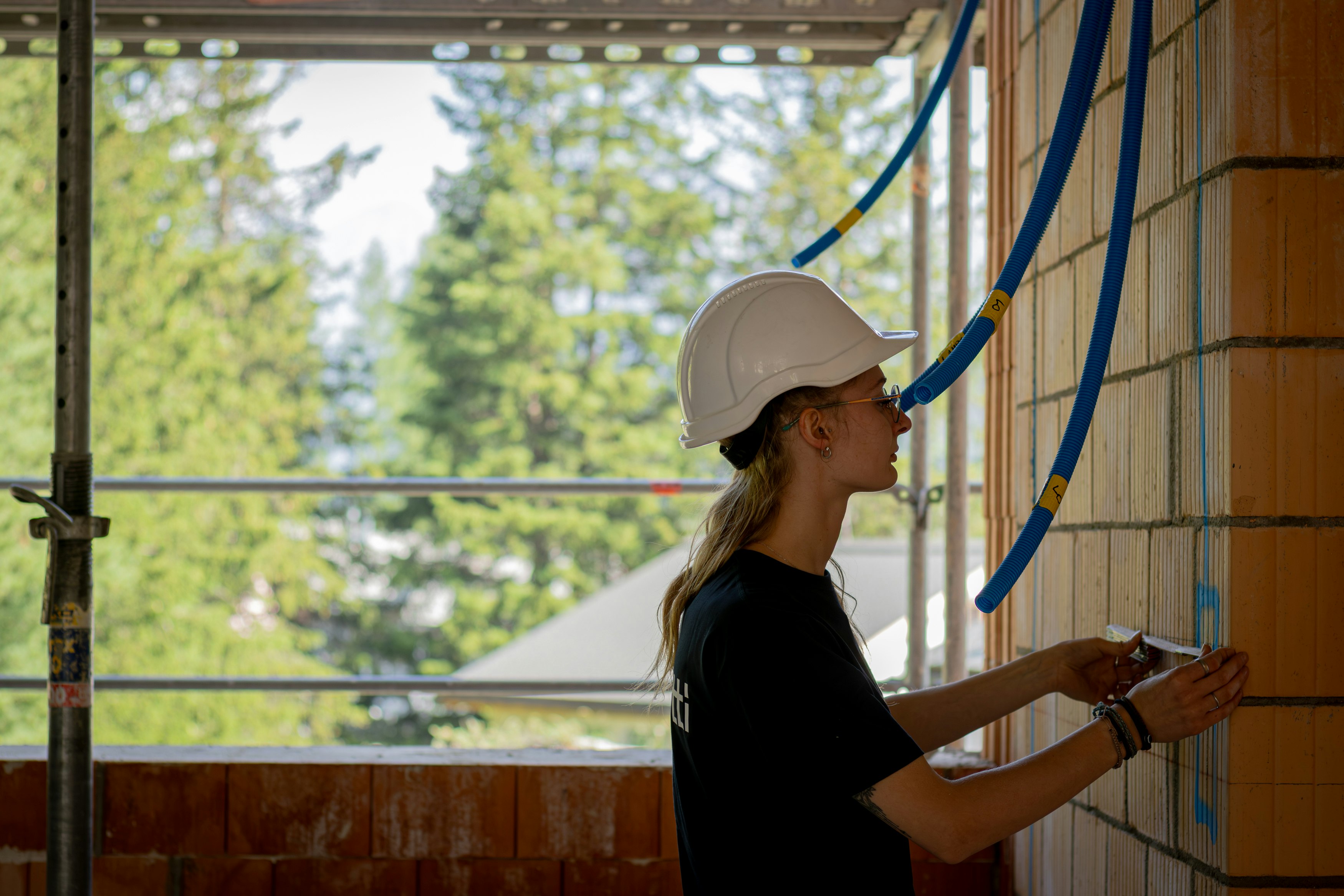 Junge Mitarbeiterin Pomatti arbeitet auf Baustelle