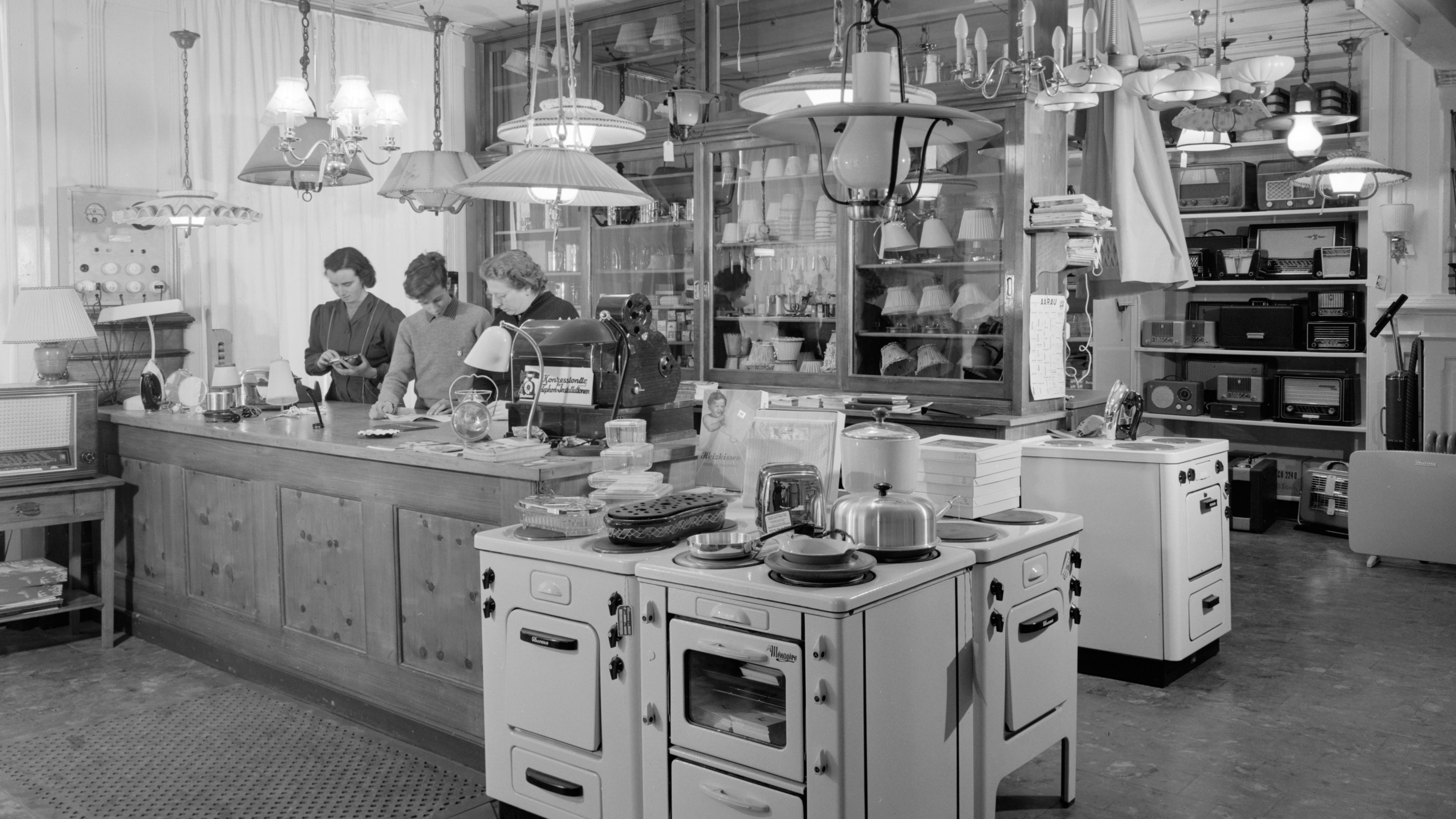 Innenansicht Pomatti Store Tresen mit Mitarbeitenden St. Moritz ca. 1954 in schwarz weiss