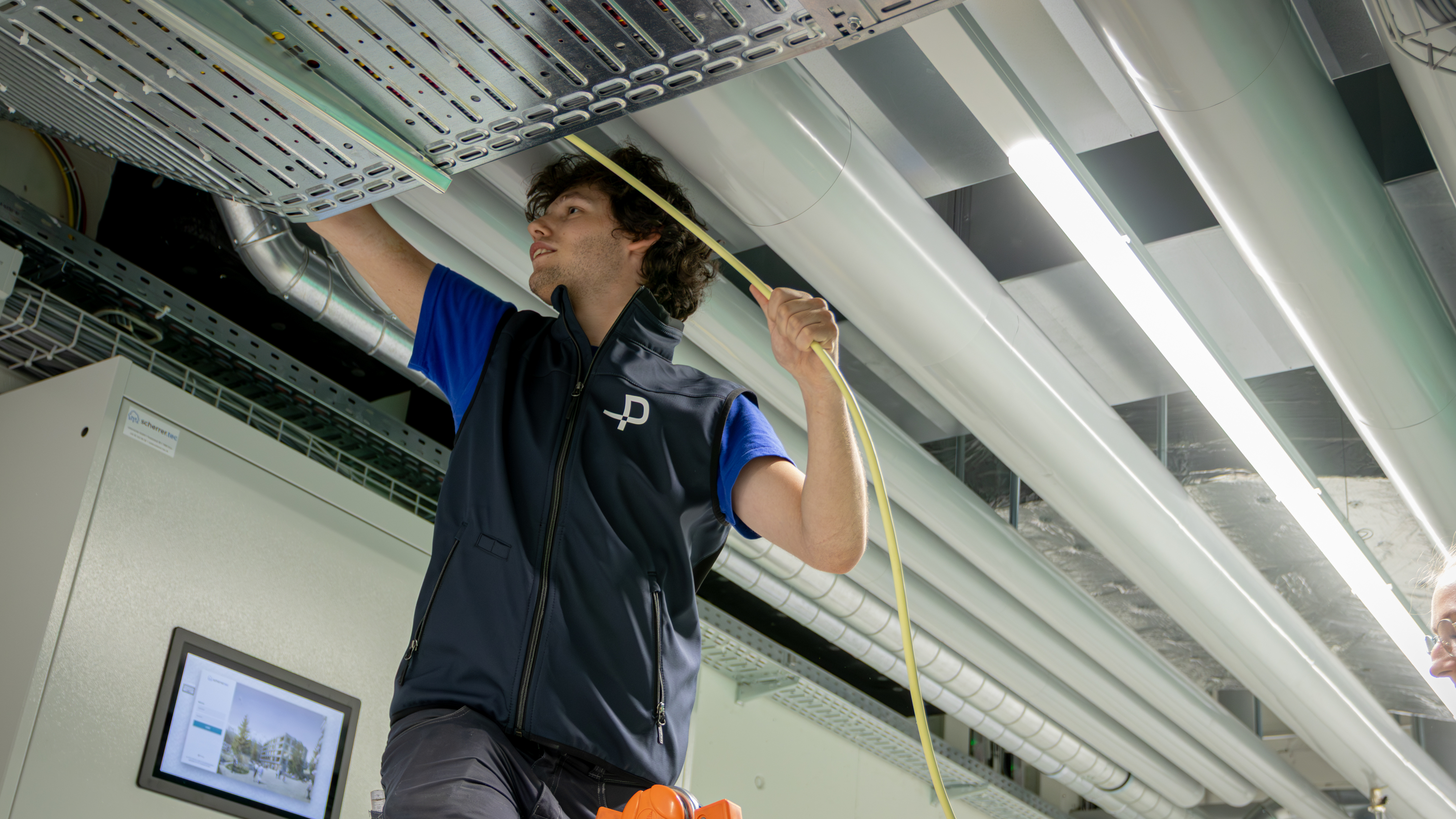 Junger Pomatti Mitarbeiter auf Baustelle verlegt Kabel