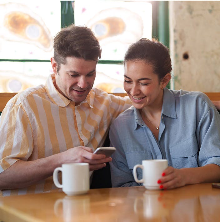 man and woman looking at a smartphone