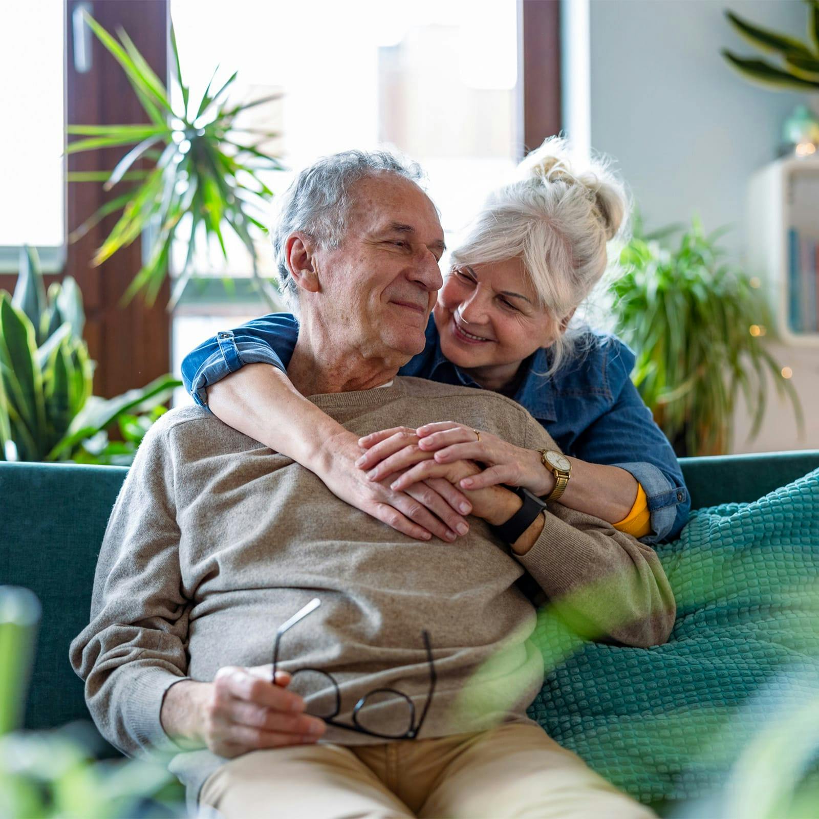 older woman hugging an older man from behind