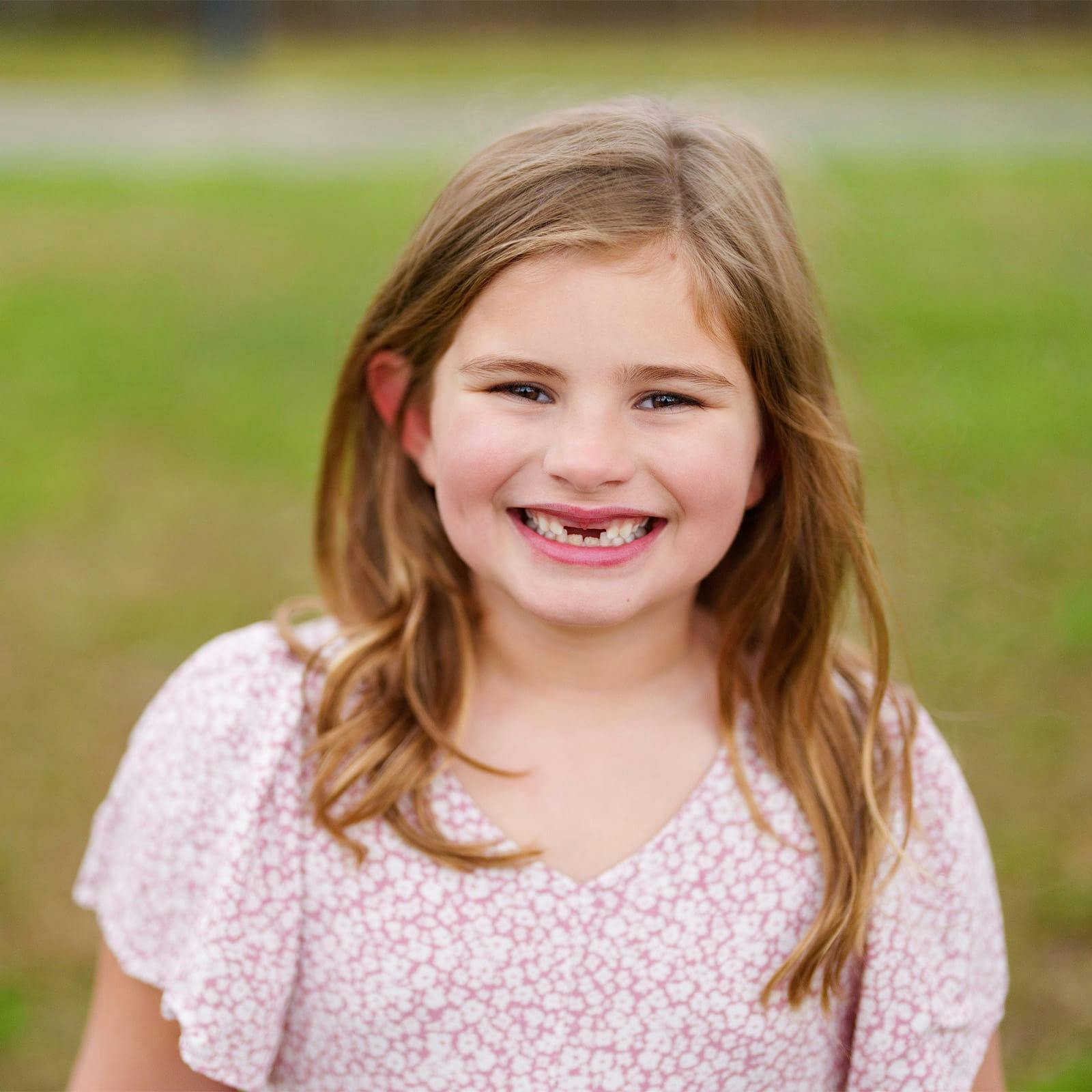 little girl with a toothless smiling