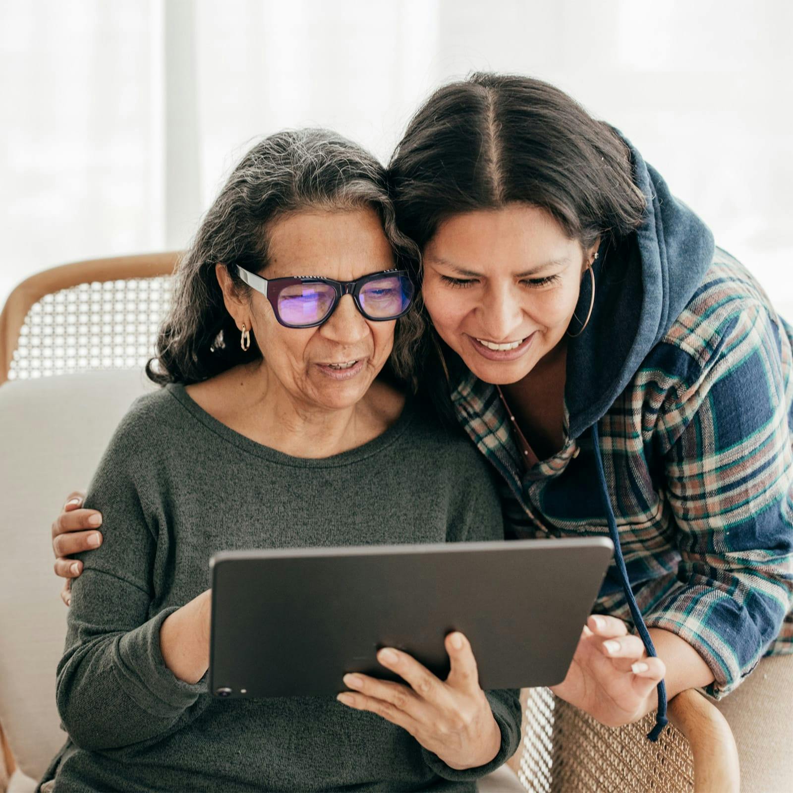two woman looking at a tablet