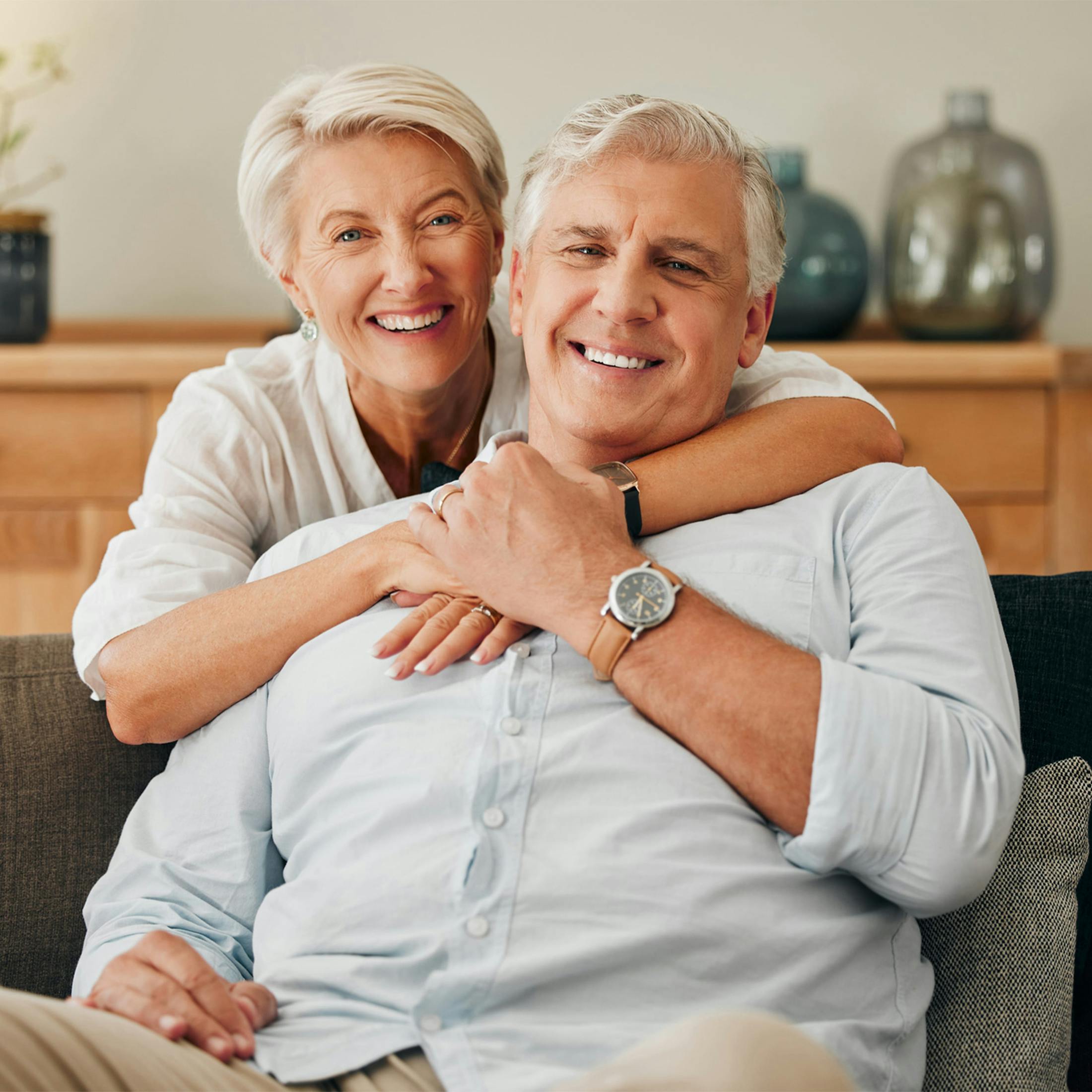 older woman hugging an older man from behind