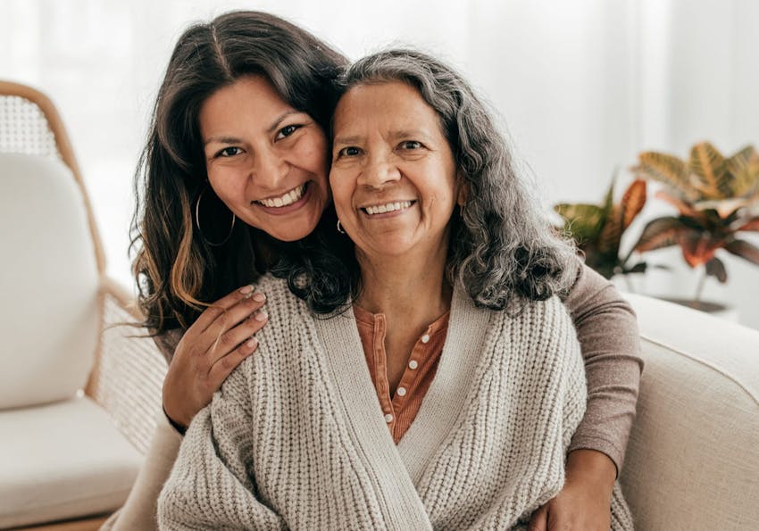 younger woman hugging older woman from behind