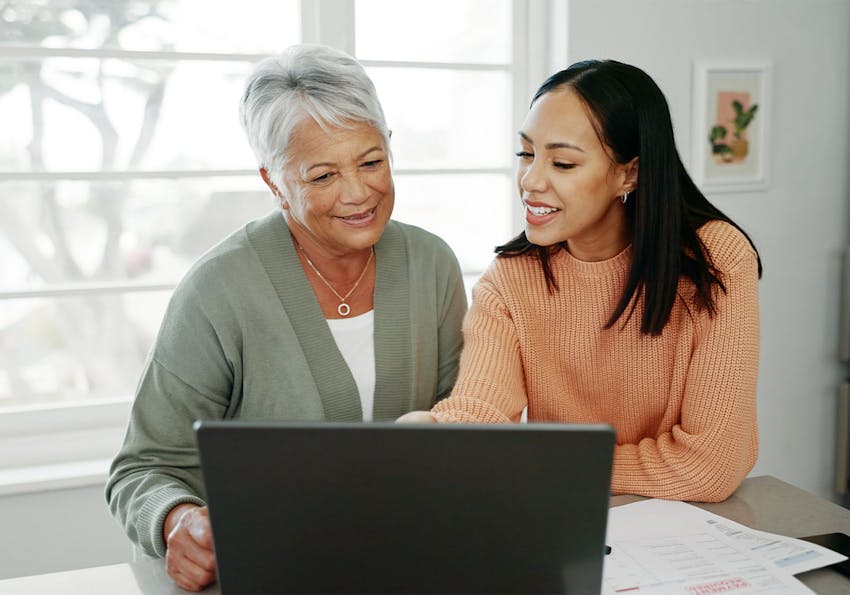 older woman and younger woman looking at a laptop