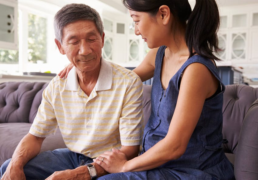 woman sitting on a couch with an older man