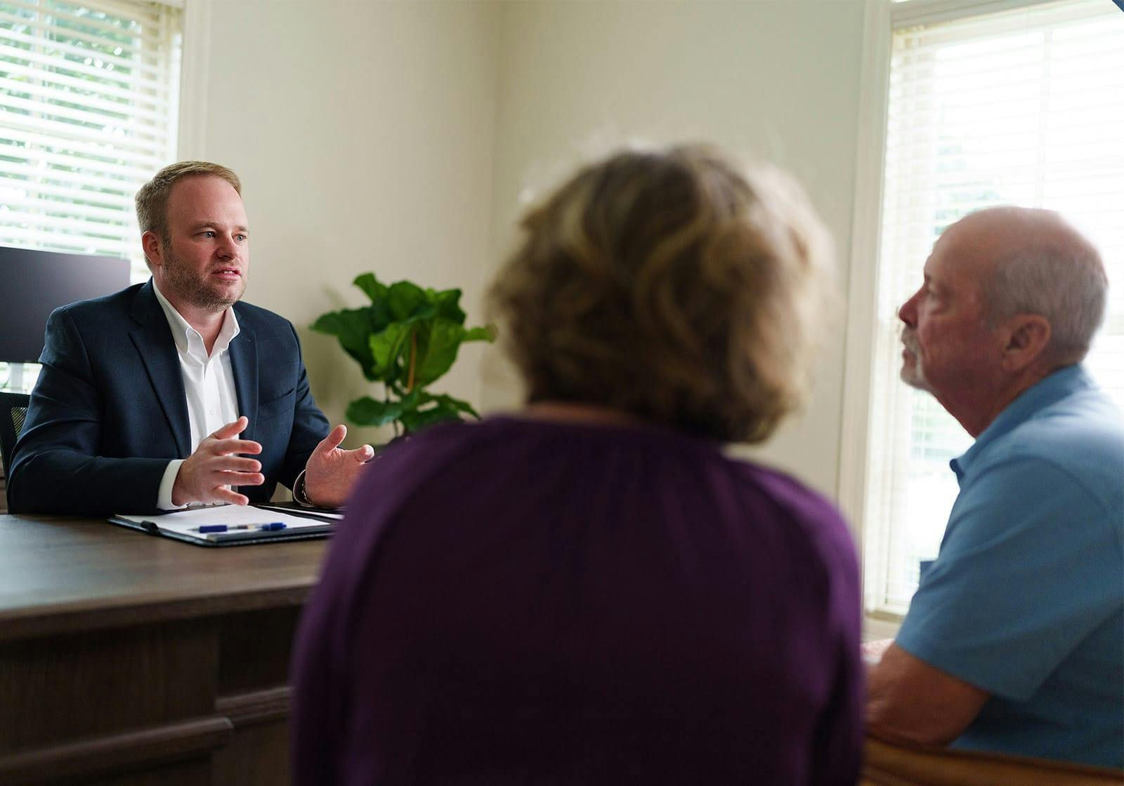 attorney talking to two clients at a desk