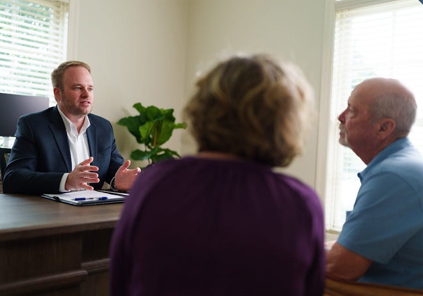 attorney talking to two clients at a desk